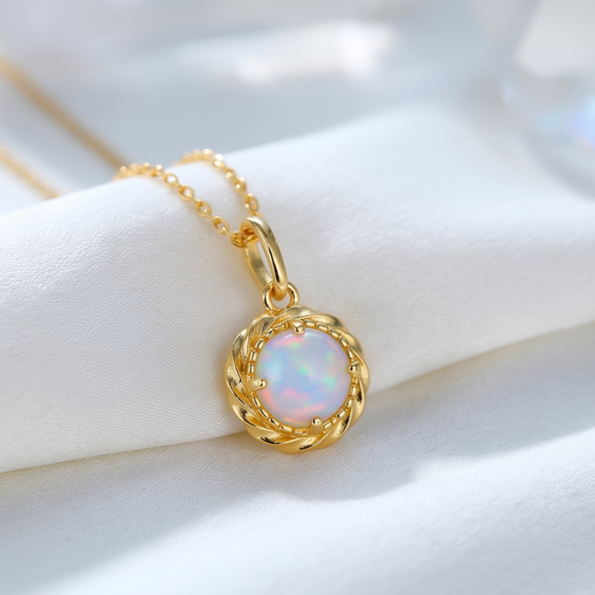 Close-up detail of the 7mm round natural opal stone and gold-tone twisted rope setting.