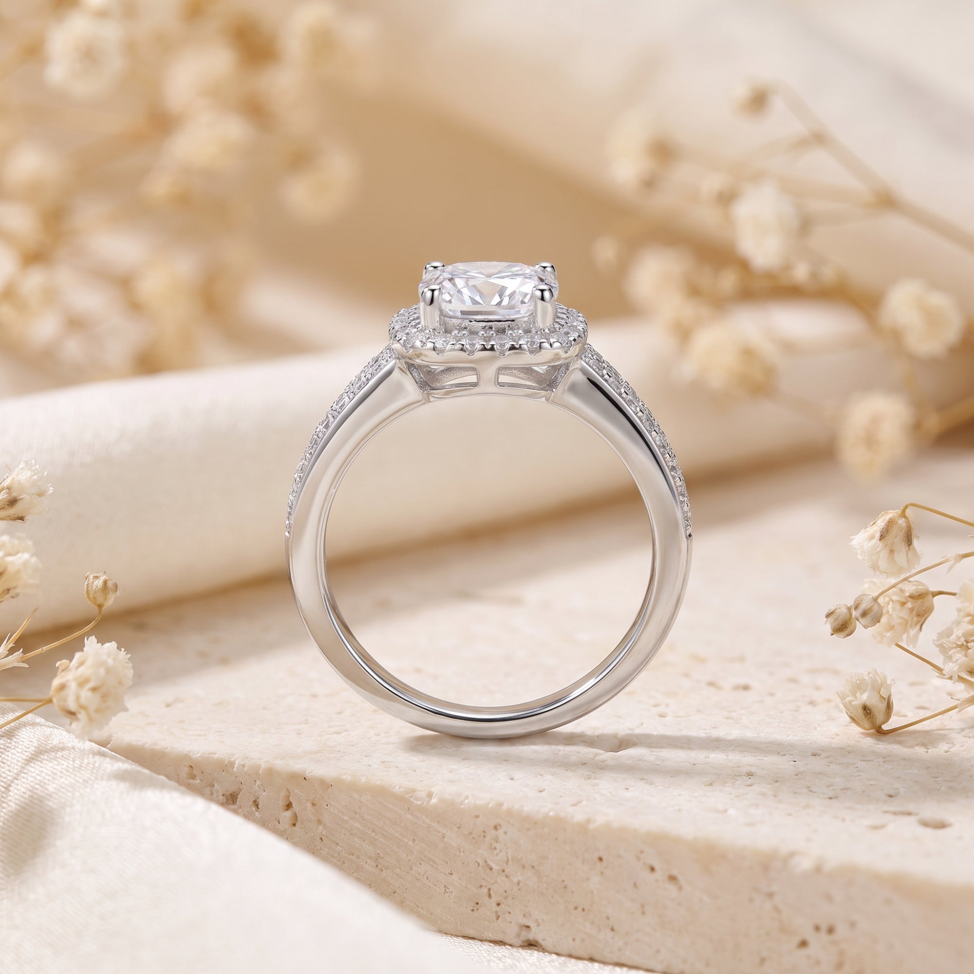 Side view of silver cushion halo ring showing setting detail.