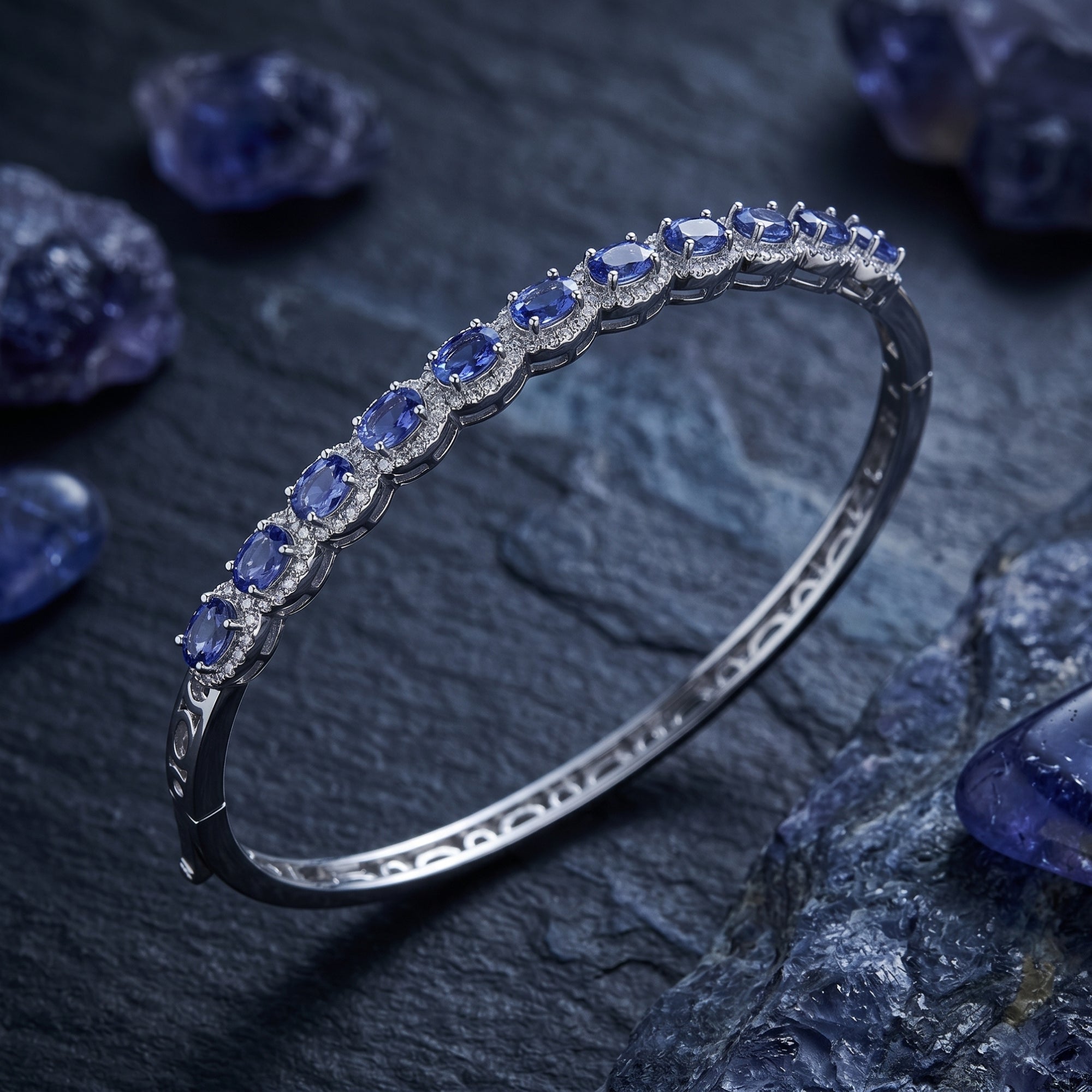 Macro view of the Alvira bangle's oval-cut natural tanzanite stones in a white gold setting.