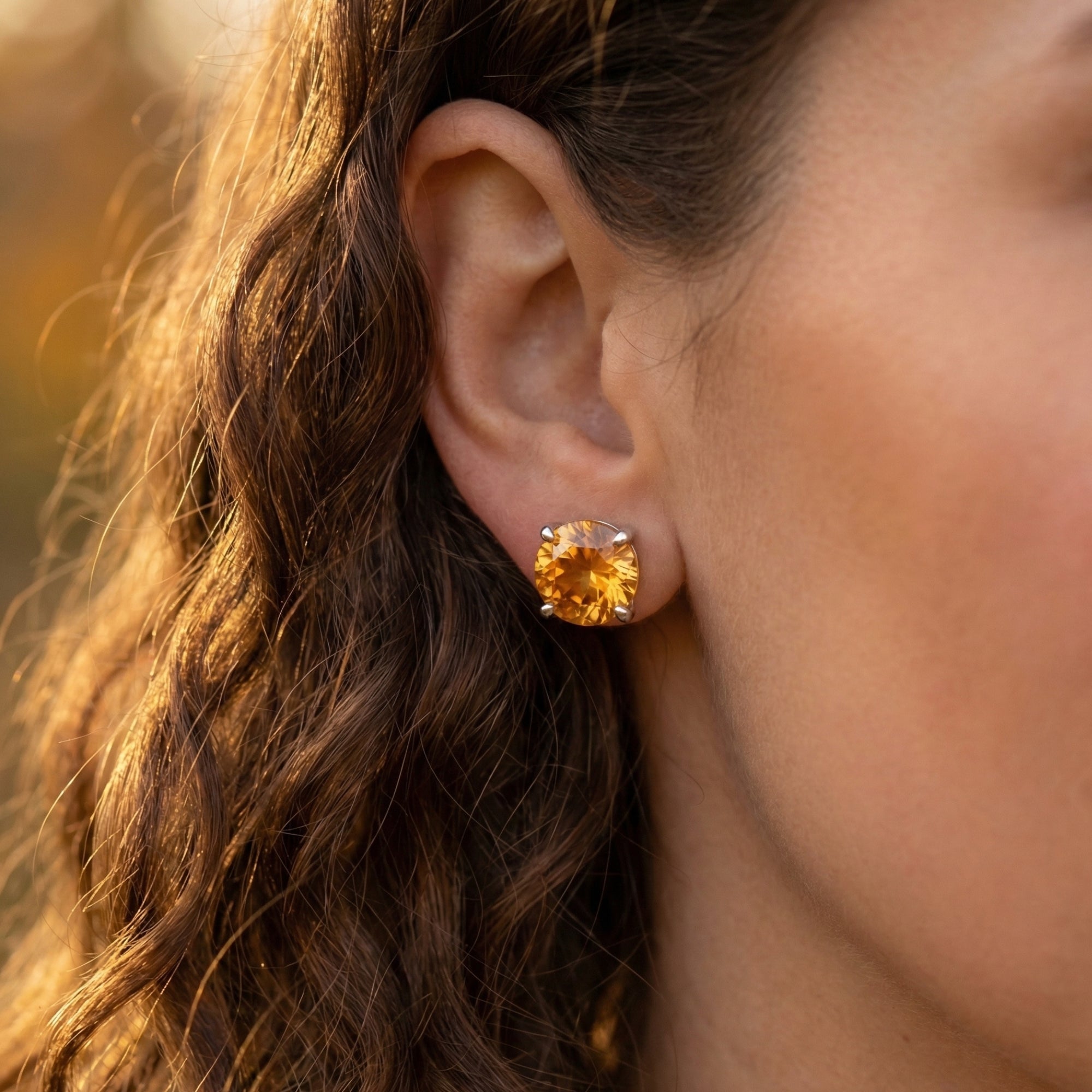 Model wearing a 12mm round cut citrine earring in sterling silver, showing the scale and brilliance.