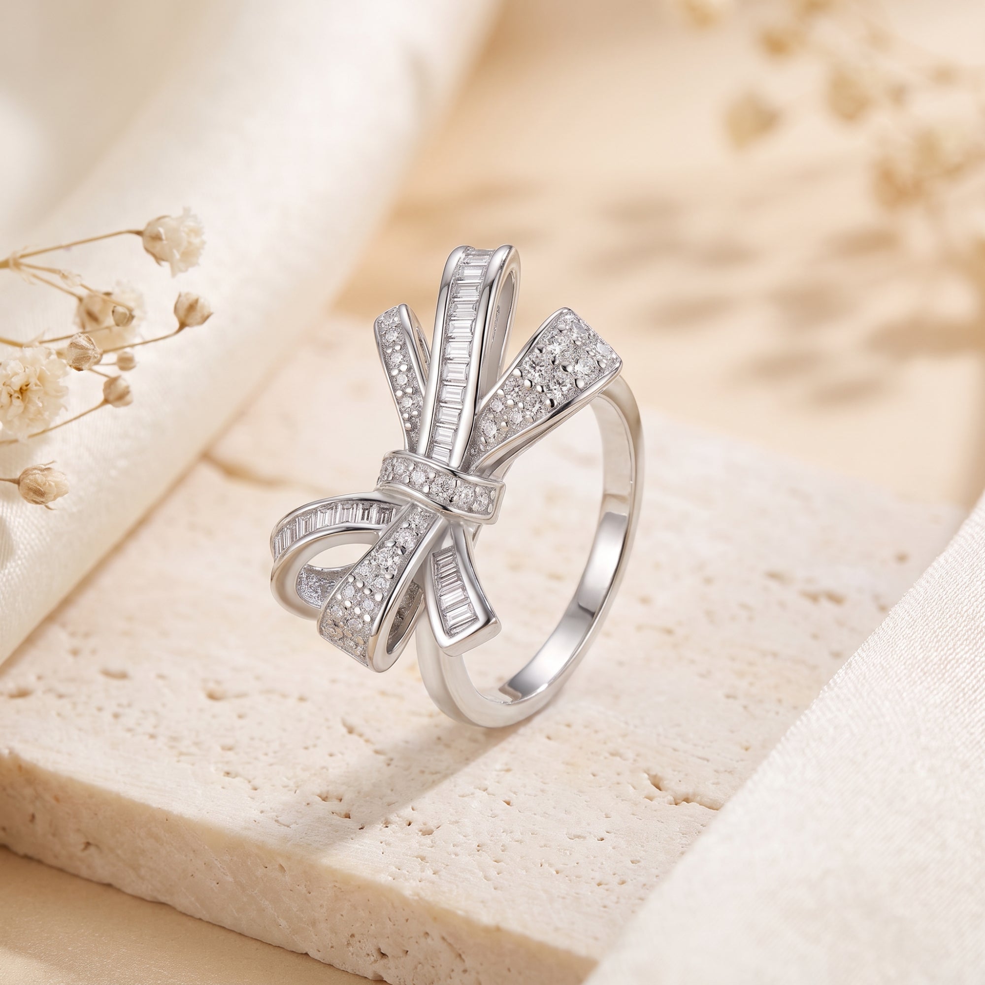 Close-up of a sterling silver bow ring featuring baguette-cut and micro-pavé diamonds.