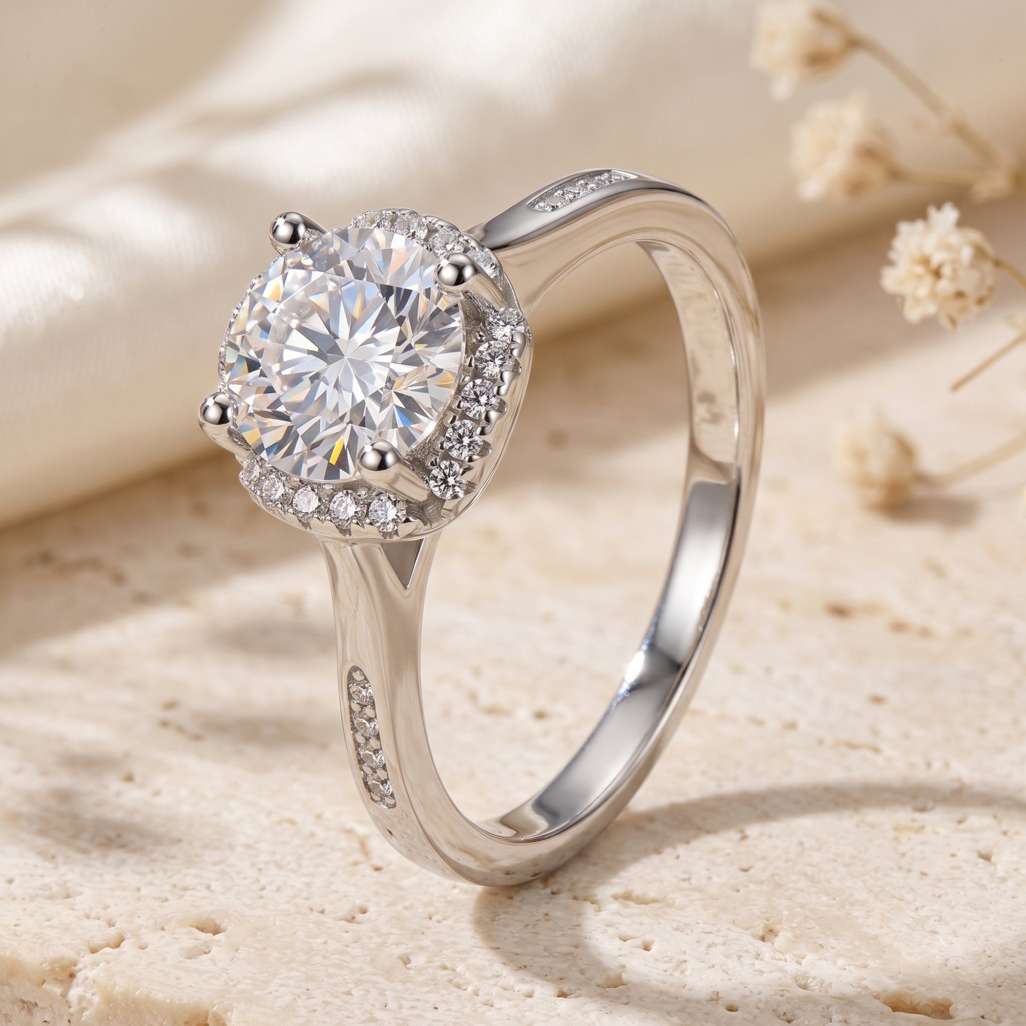 Side view of silver halo ring showing round cubic zirconia and pavé shoulders.