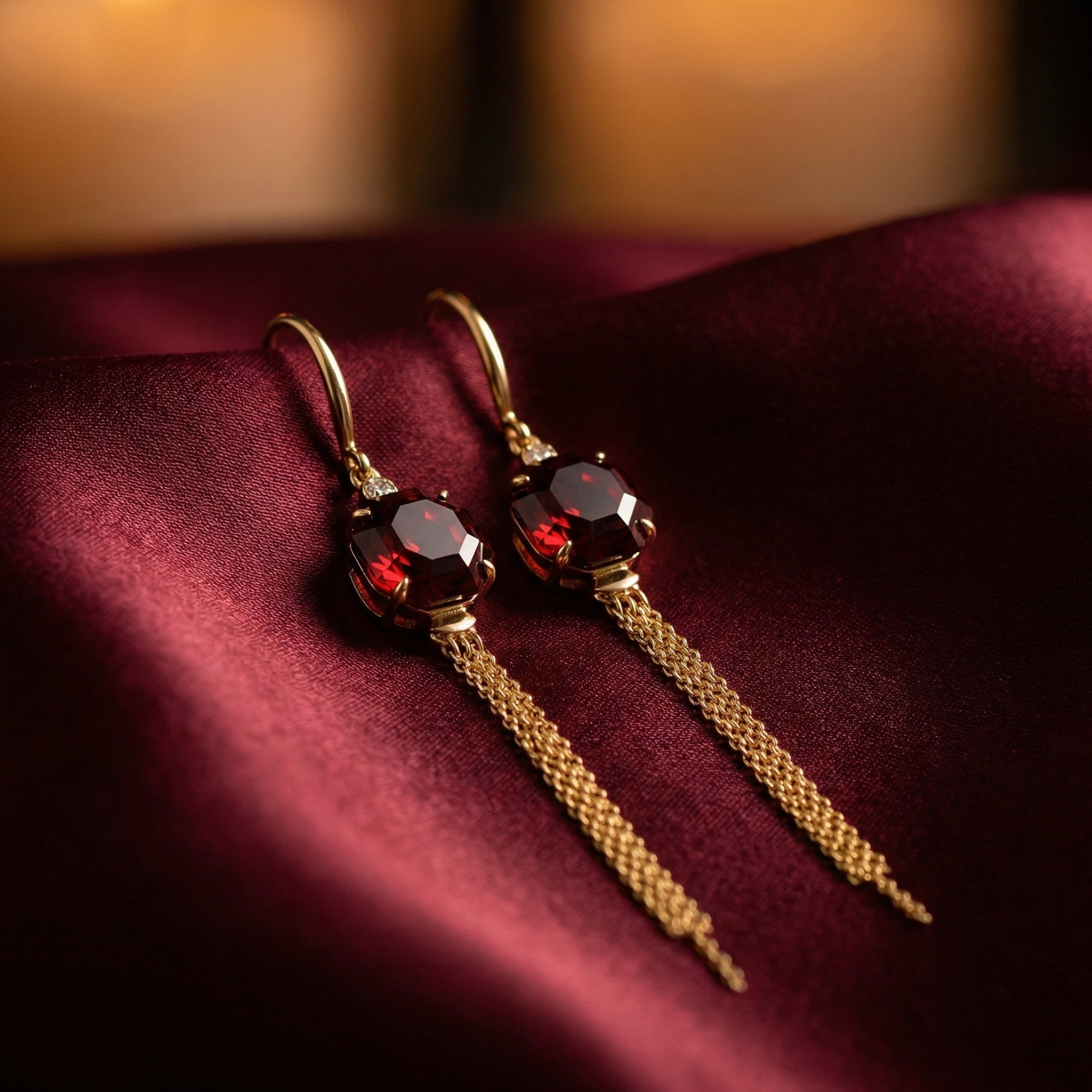 Close-up of octagon-cut natural garnet drop earrings in 18K yellow gold showing the detailed chain tassels.