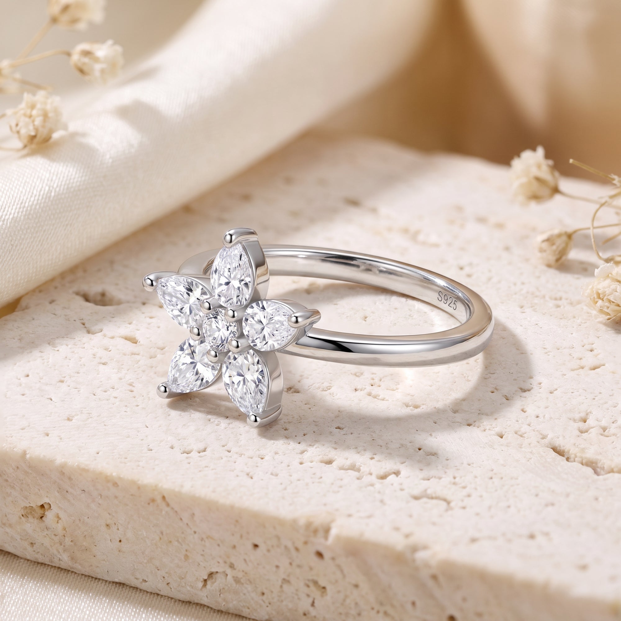 Side view of silver flower ring showing pear-cut stones and S925 hallmark.