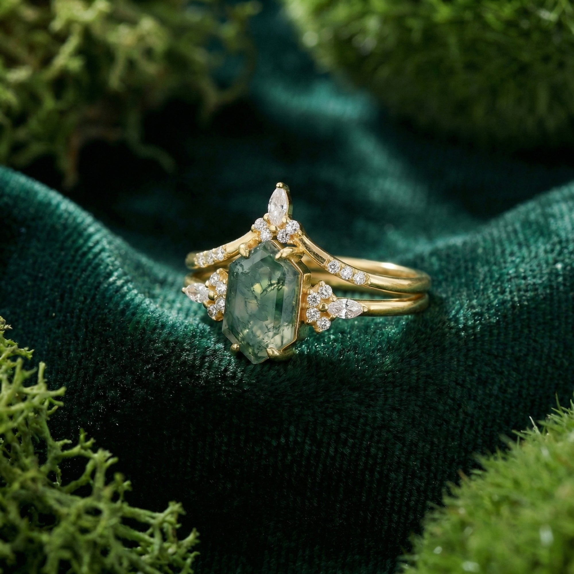 Detailed view of the hexagonal moss agate and gold-plated sterling silver setting on green velvet.