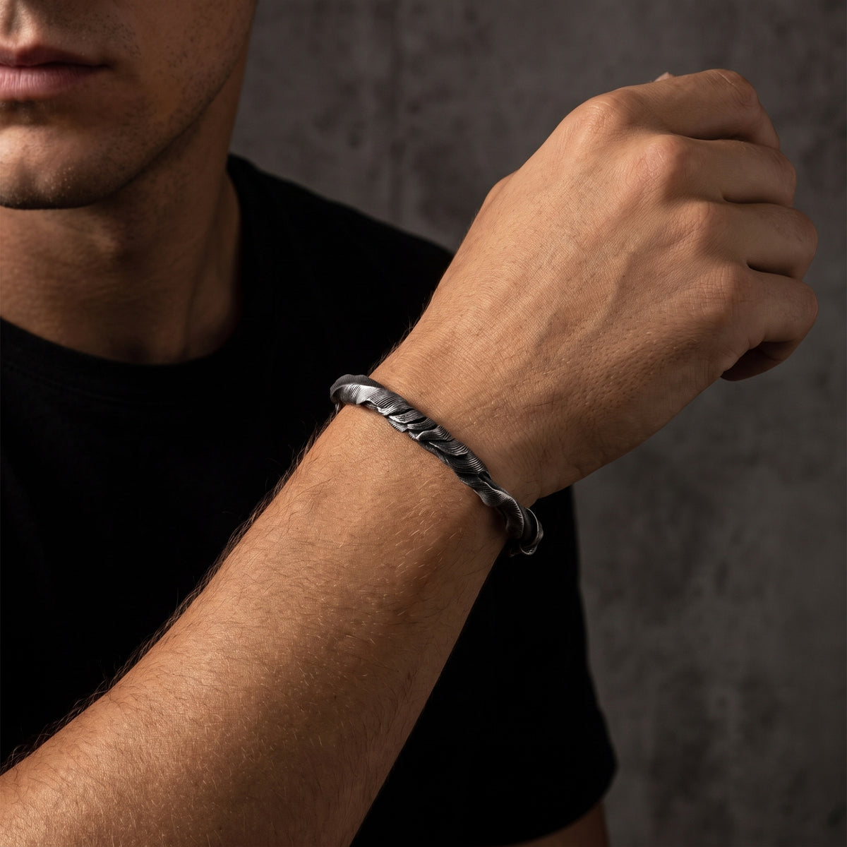 Man wearing the silver feathered twist open cuff bracelet on his raised arm.