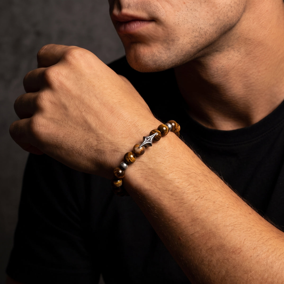Close-up of the North Star beaded bracelet with brown gemstone beads and a silver star station worn on a man's wrist
