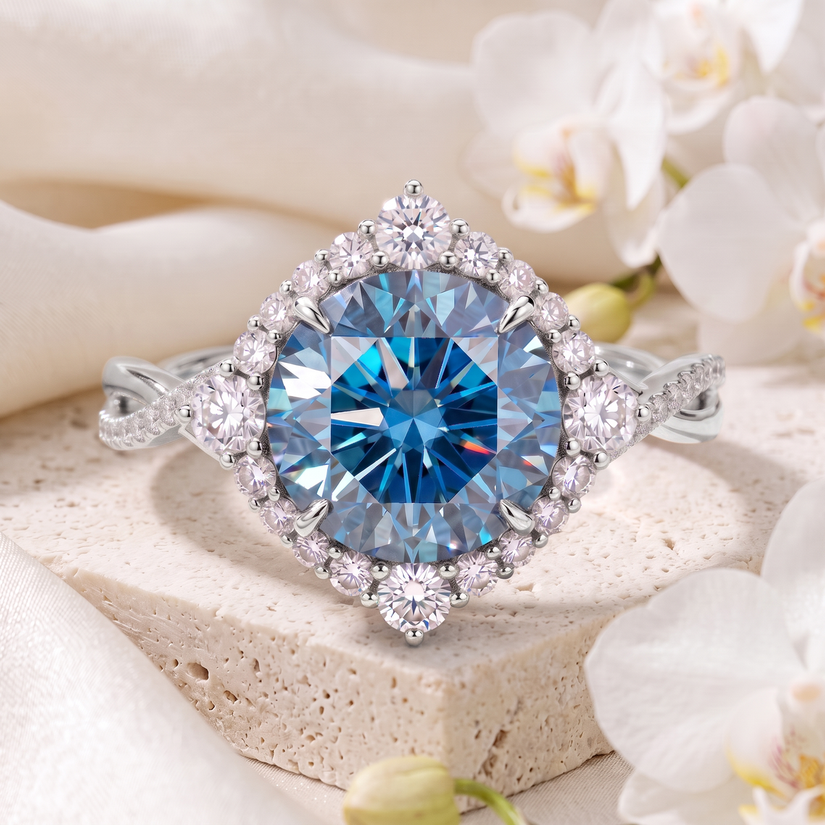 Front view of a round blue moissanite halo ring in white gold with a twisted pavé band.