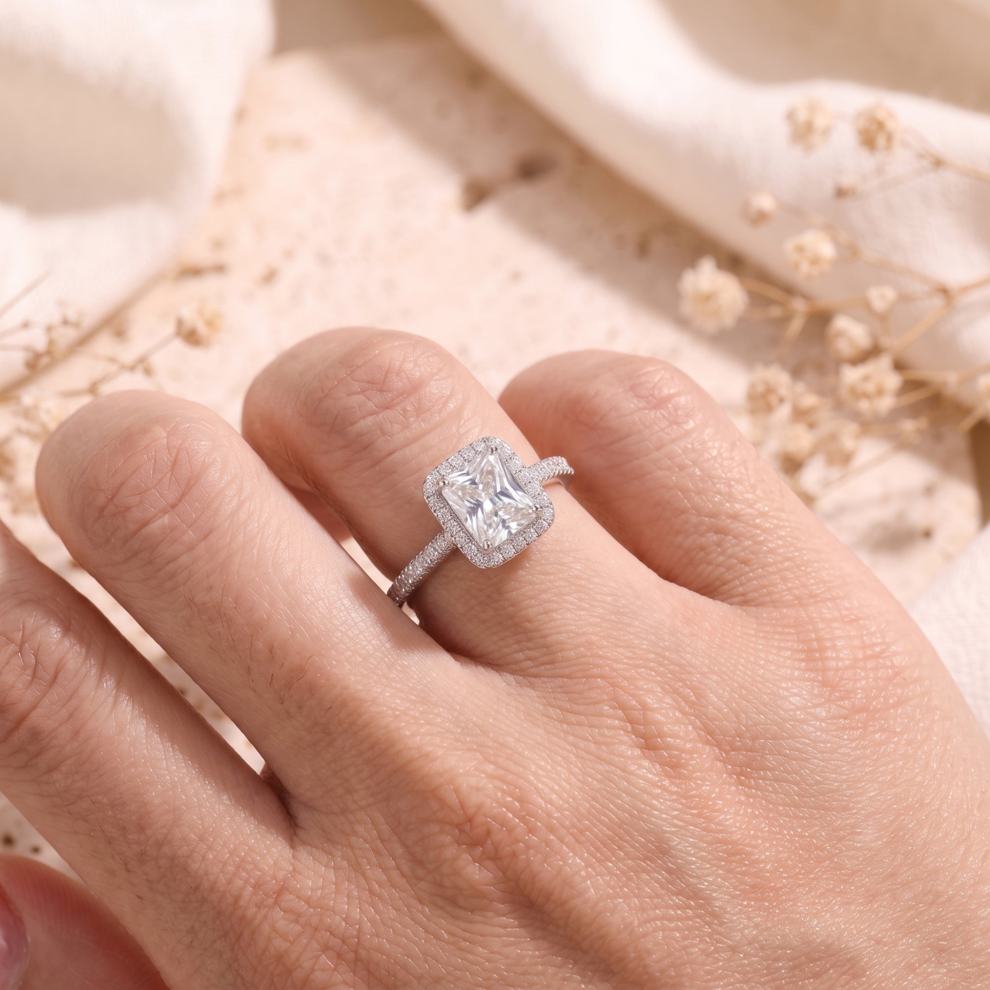 Close-up of the radiant-cut cubic zirconia halo promise ring in sterling silver shown on a hand.