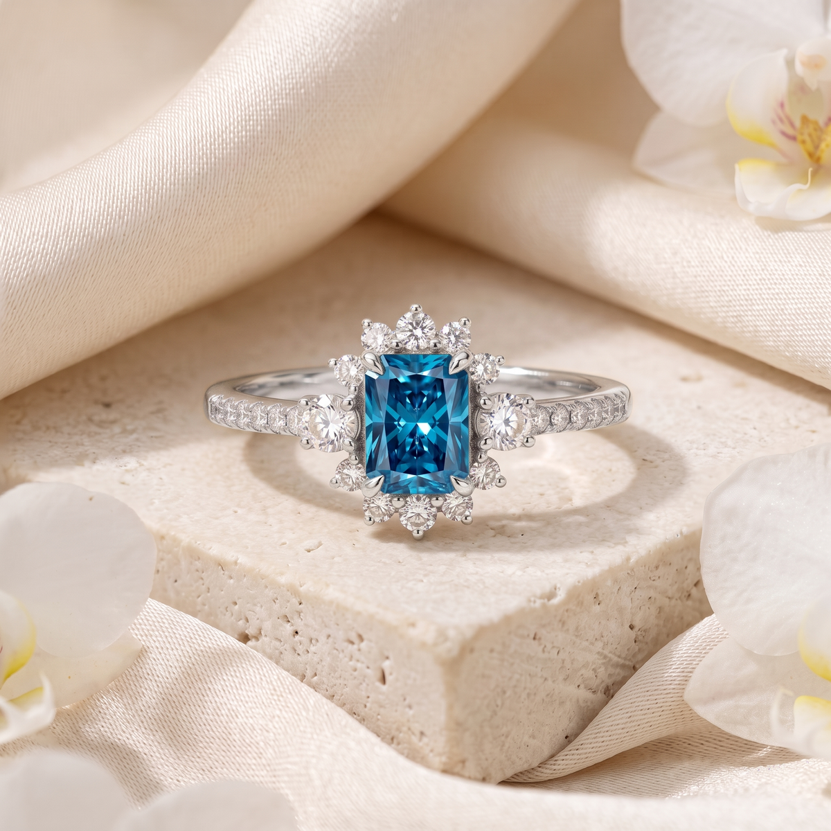 Front view of white gold radiant-cut blue moissanite engagement ring with sparkling diamond halo.