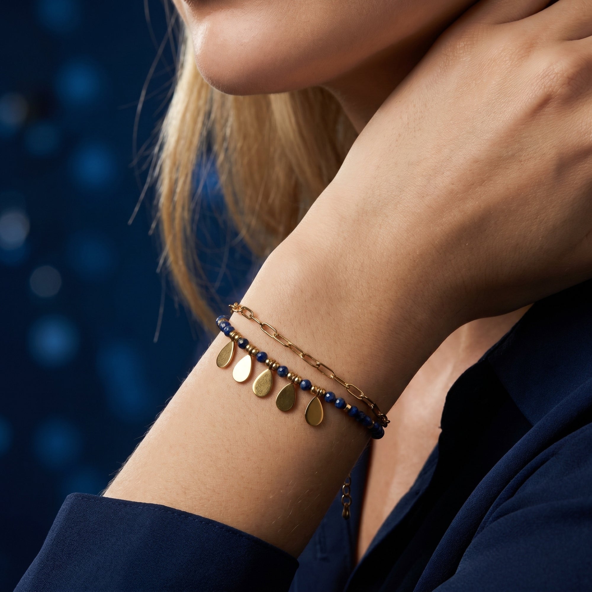 Close-up of the Sylvan Leaf double-layered gold plated bracelet with faceted lapis beads on a woman's wrist.