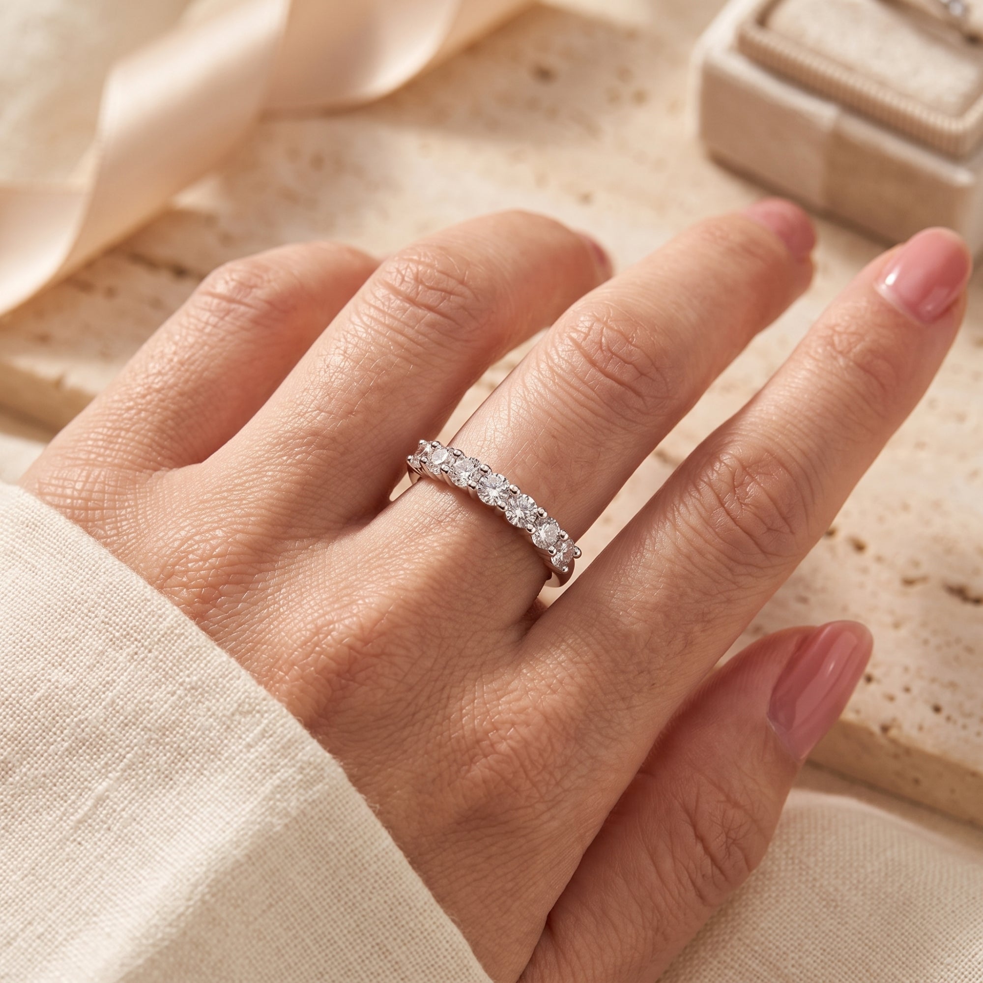 S925 sterling silver seven-stone promise ring with round-cut stones worn on a finger in a lifestyle setting.