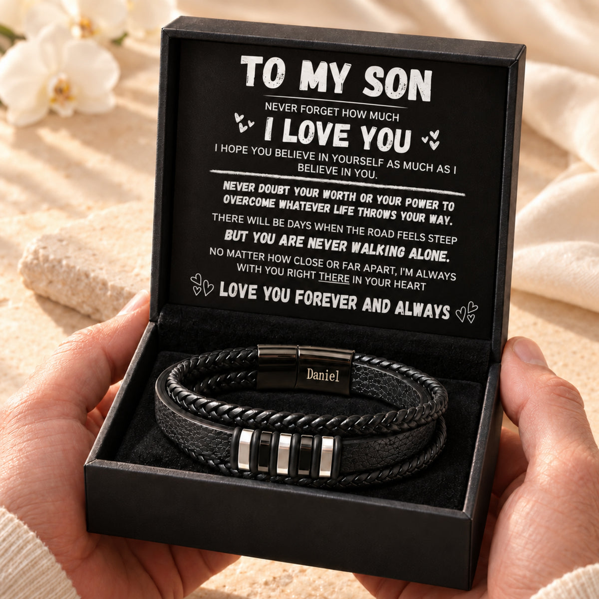 Hands presenting the son bracelet and Never Walking Alone message card