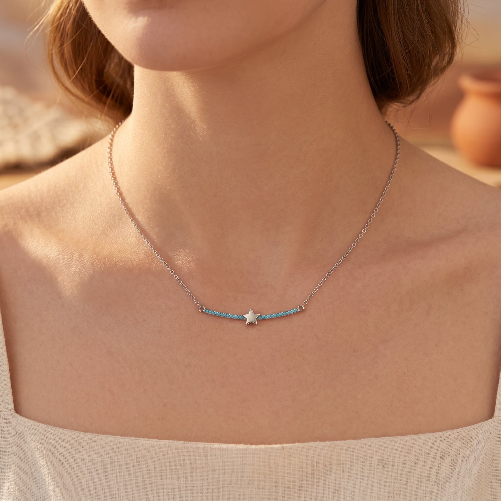 Model wearing the silver Phoenix Star turquoise necklace with a white linen top for a casual, elegant look.