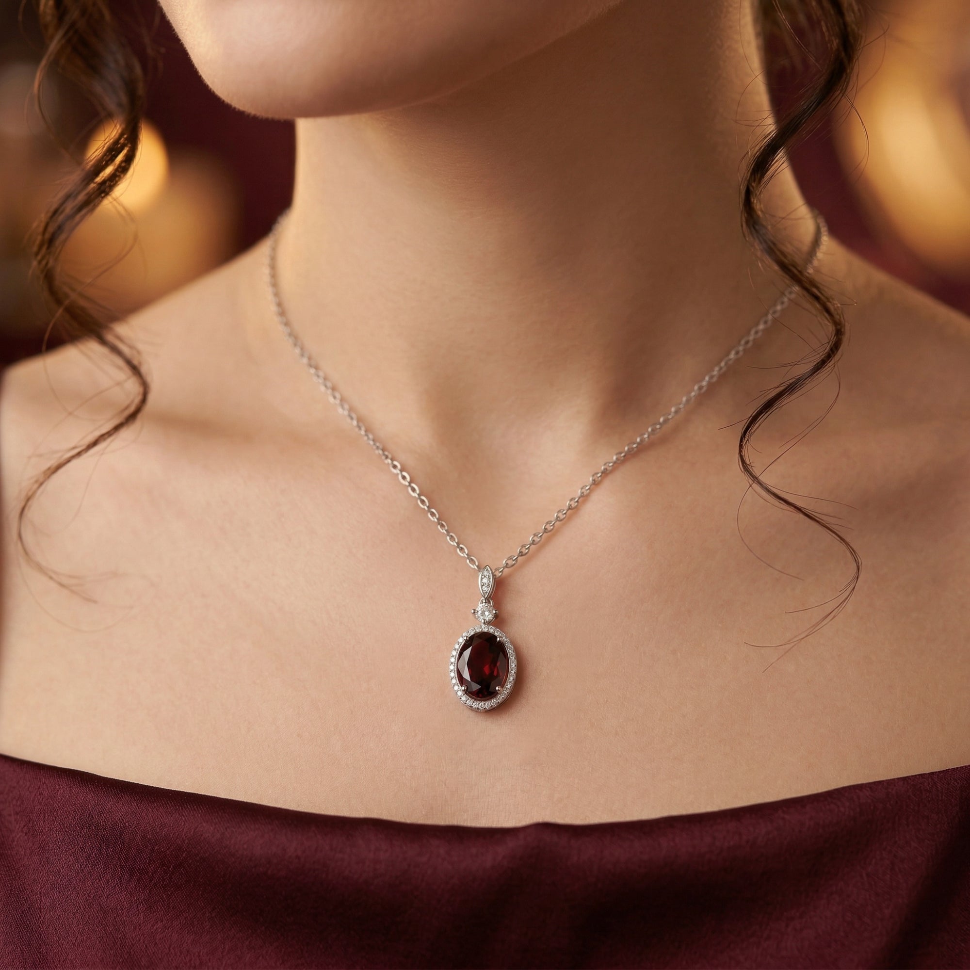 Sterling silver oval garnet necklace worn by a model, showcasing its length and fit on the neckline.