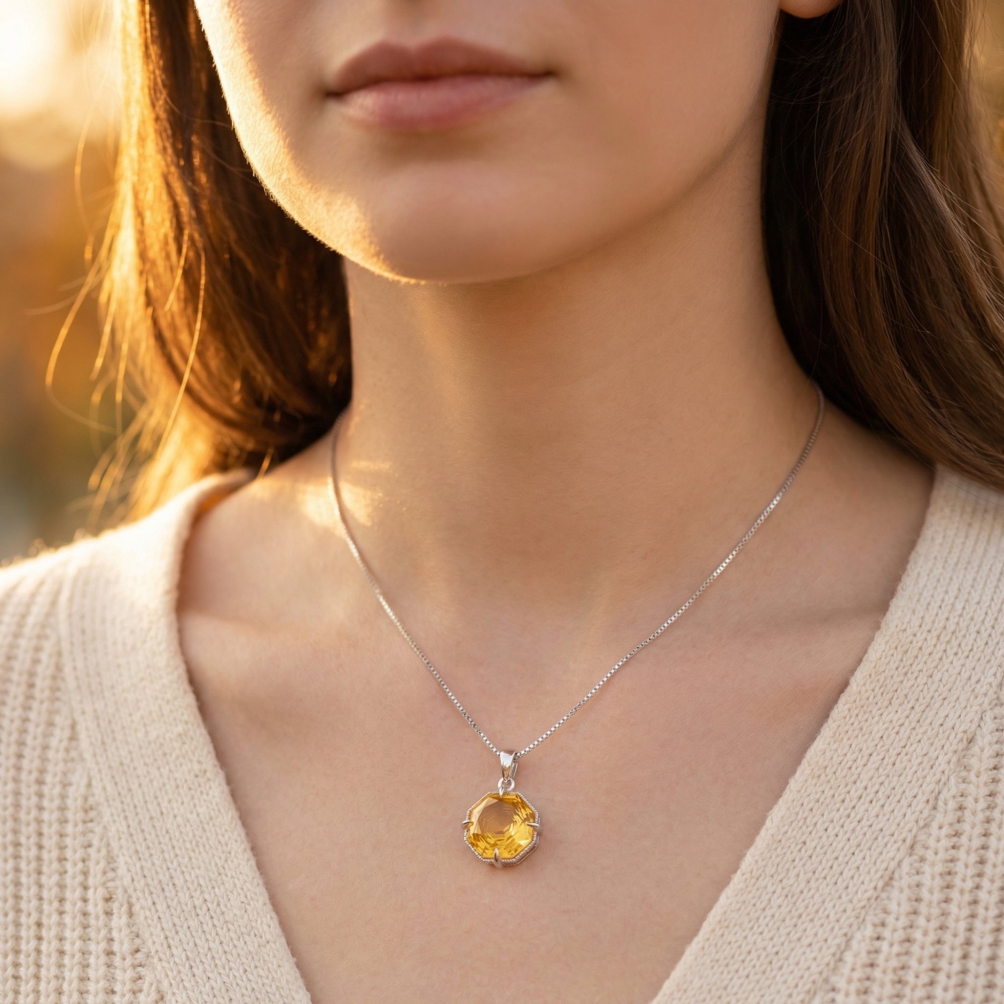 Model wearing the natural citrine octagon necklace in sterling silver, paired with a neutral knit sweater.