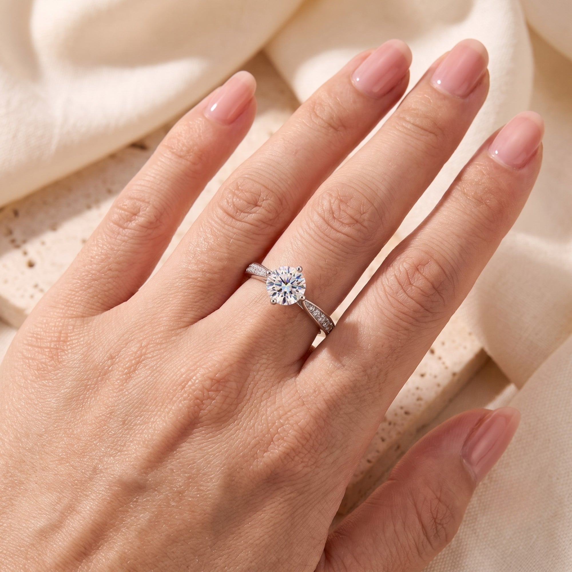 Top view of the sterling silver round cut micro-pavé solitaire ring on a model's hand to show scale and fit.