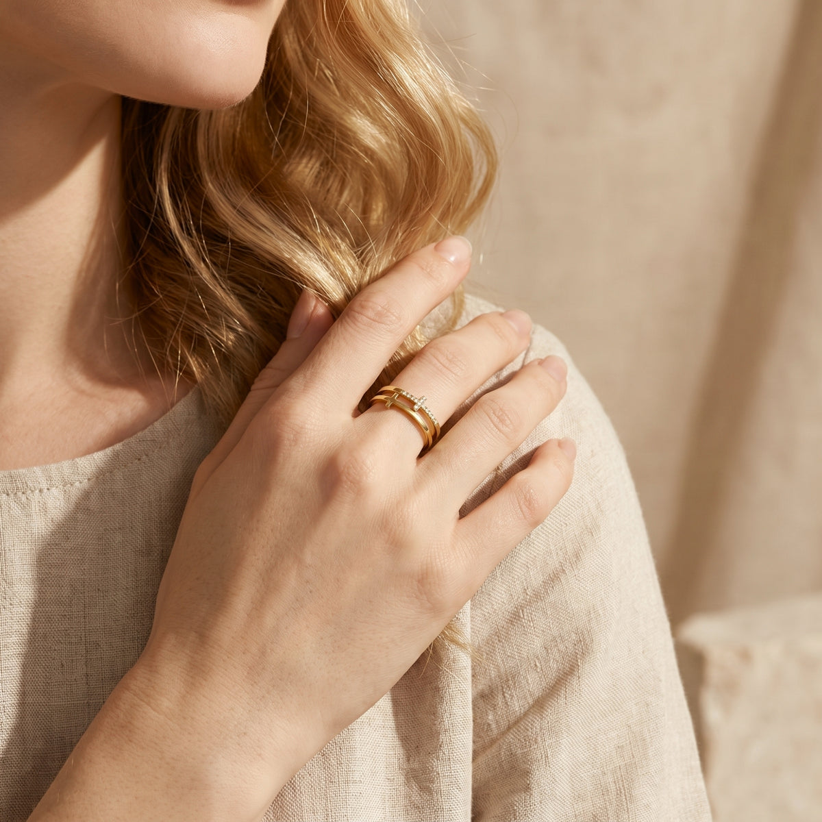 Model wearing the gold dual-band cross ring while touching her hair.