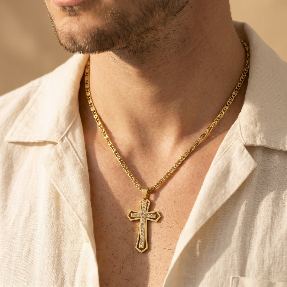 Centered front view of a man wearing the gold-tone cross necklace with clear cubic zirconia crystals.