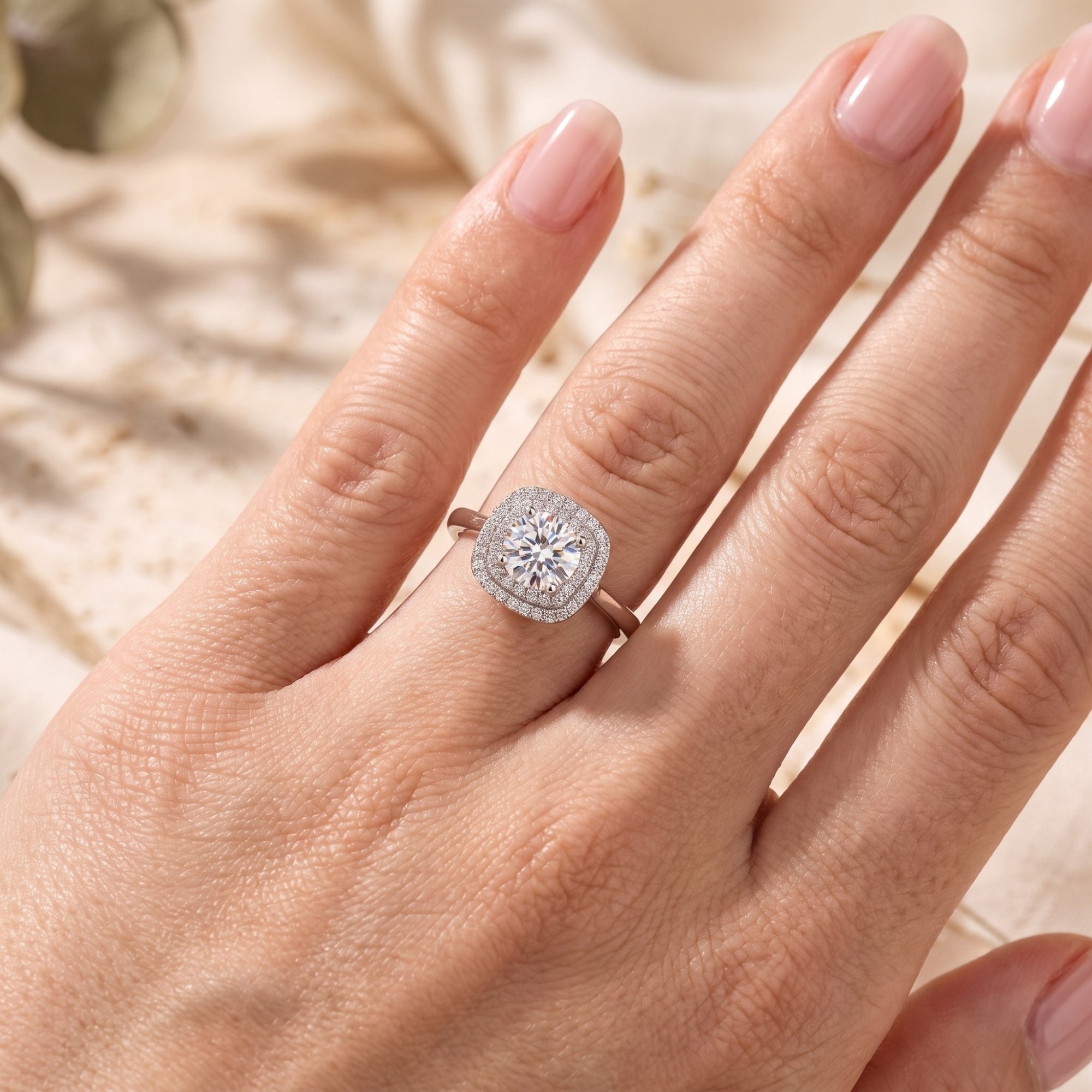 Sterling silver double halo promise ring with a round cubic zirconia center stone shown on a hand.