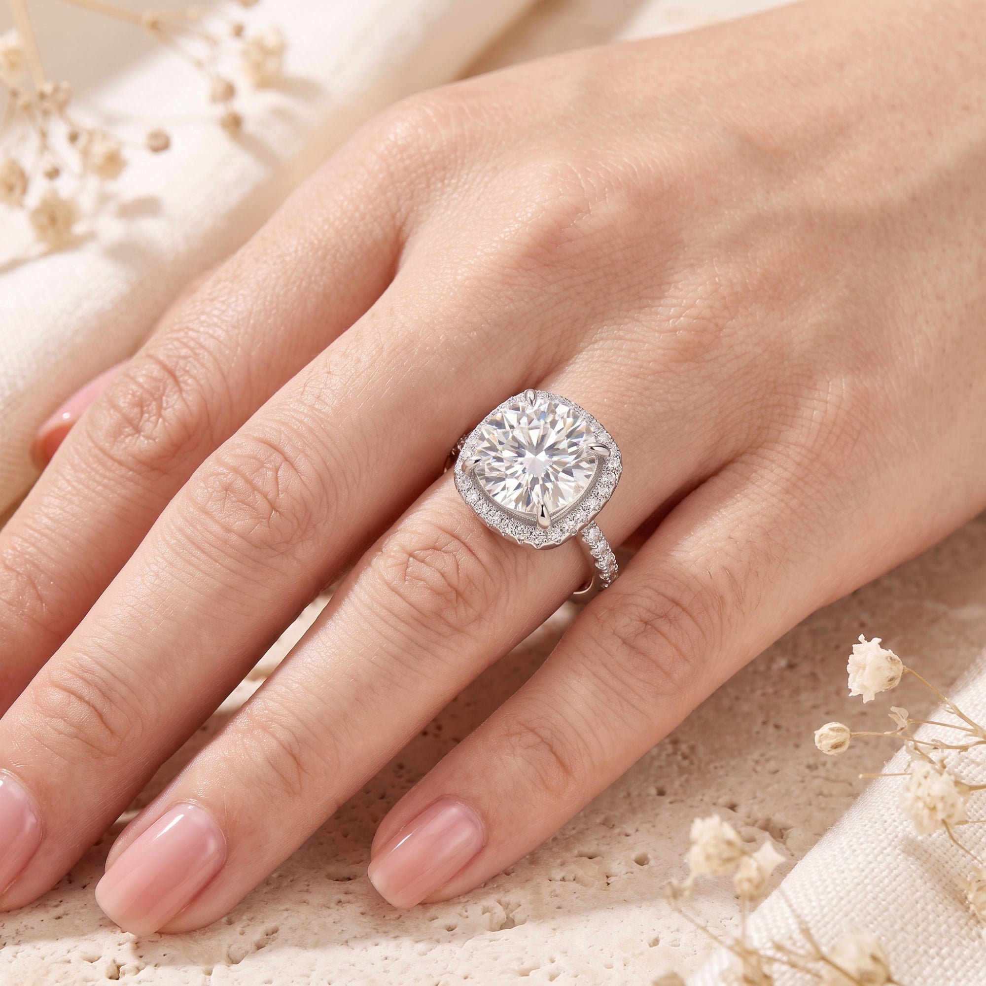Top-down view of the sterling silver cushion halo solitaire ring with a round brilliant-cut cubic zirconia on a hand.