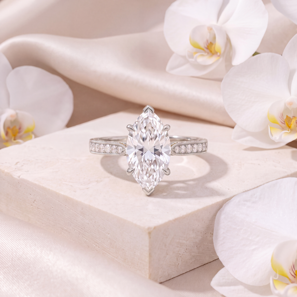 Front view of a white gold marquise moissanite engagement ring on a stone pedestal.
