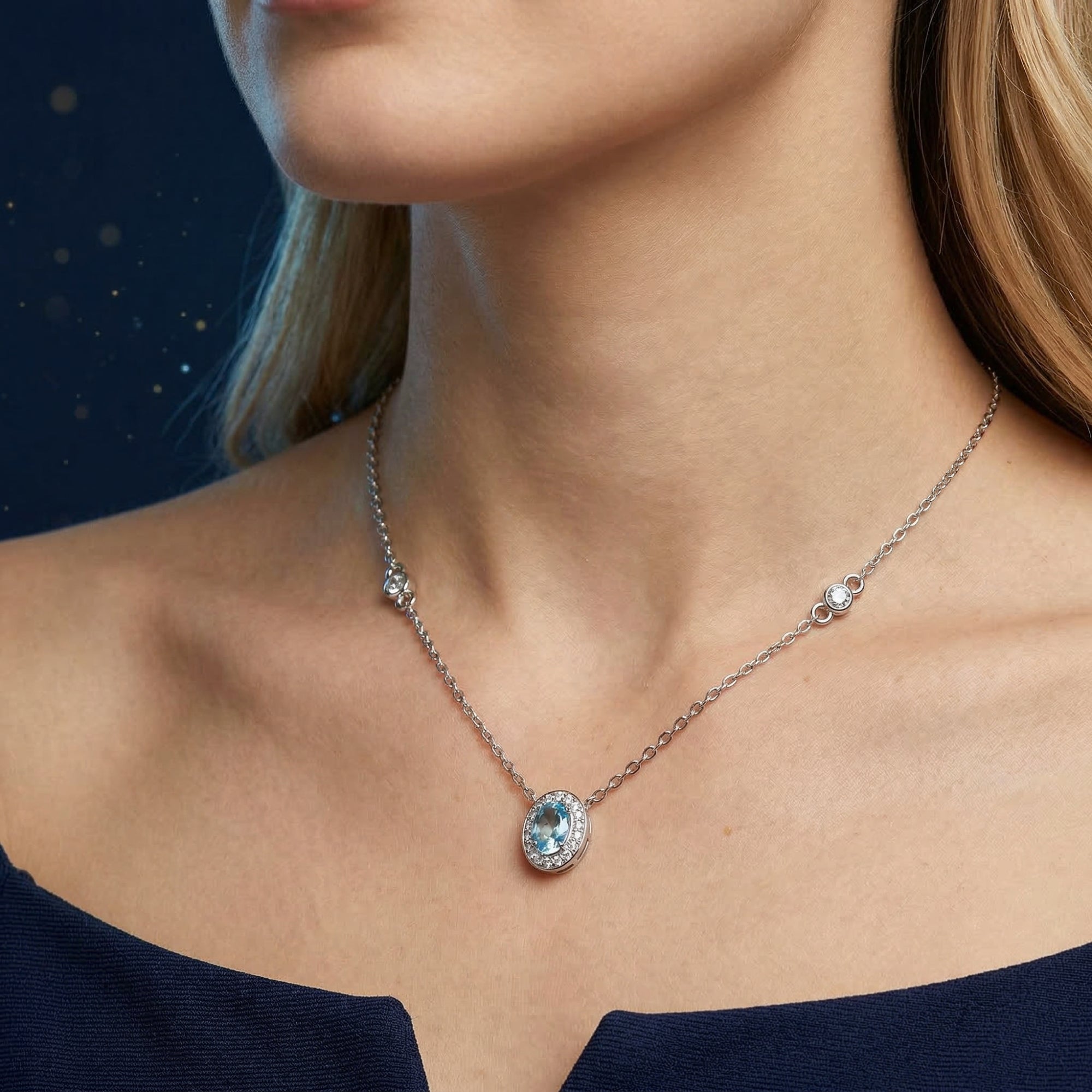 Close-up of a woman wearing the natural blue topaz necklace in white gold, highlighting the oval cut stone.