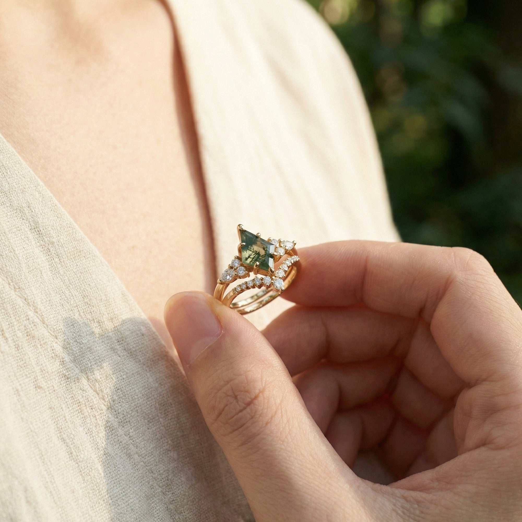 Close-up of a hand holding the kite-cut moss agate duo ring set in gold-plated sterling silver.