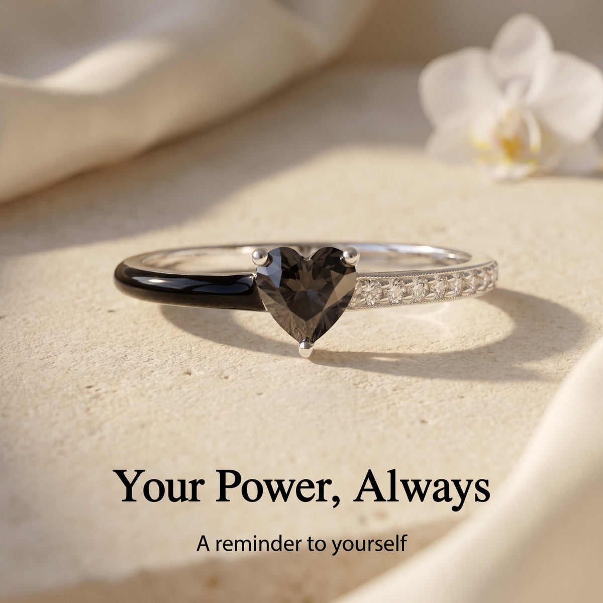 Close-up of the black heart and black enamel band, with the Your Power, Always reminder.