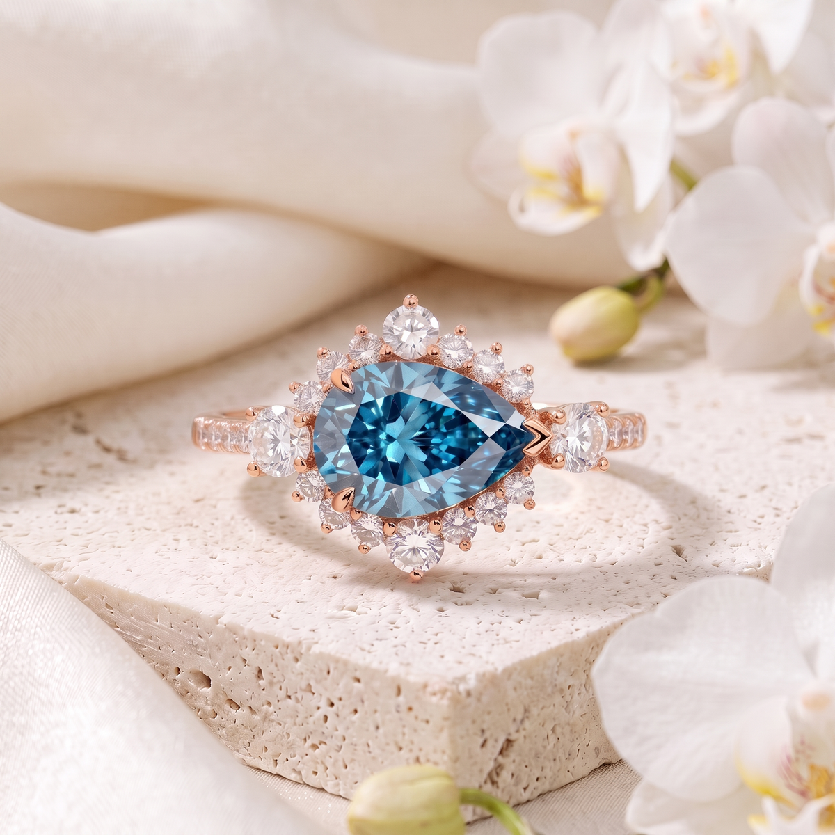 Front view of a pear cut blue moissanite halo engagement ring in rose gold.