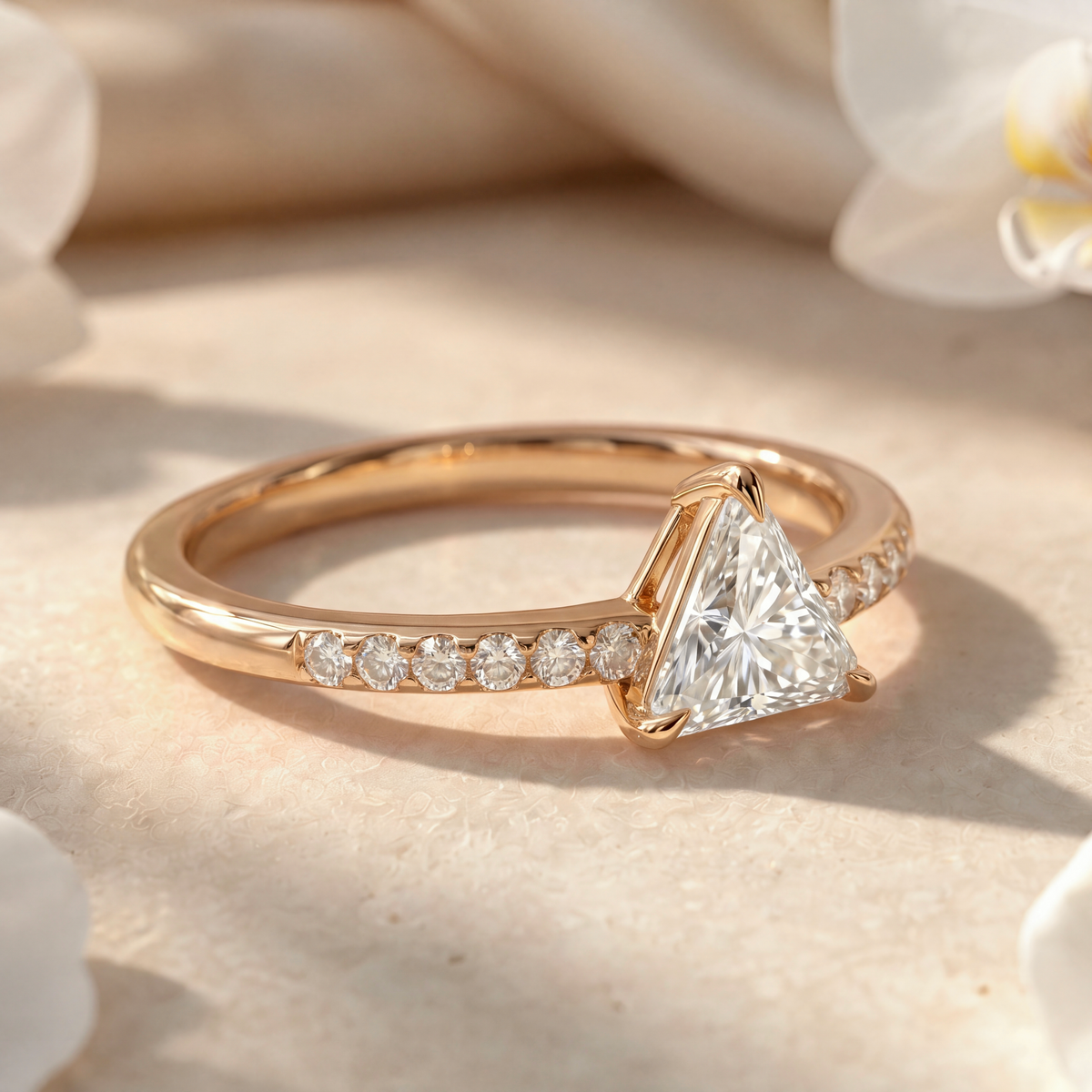 Side view of the yellow gold trillion-cut moissanite ring highlighting setting details and pave band.
