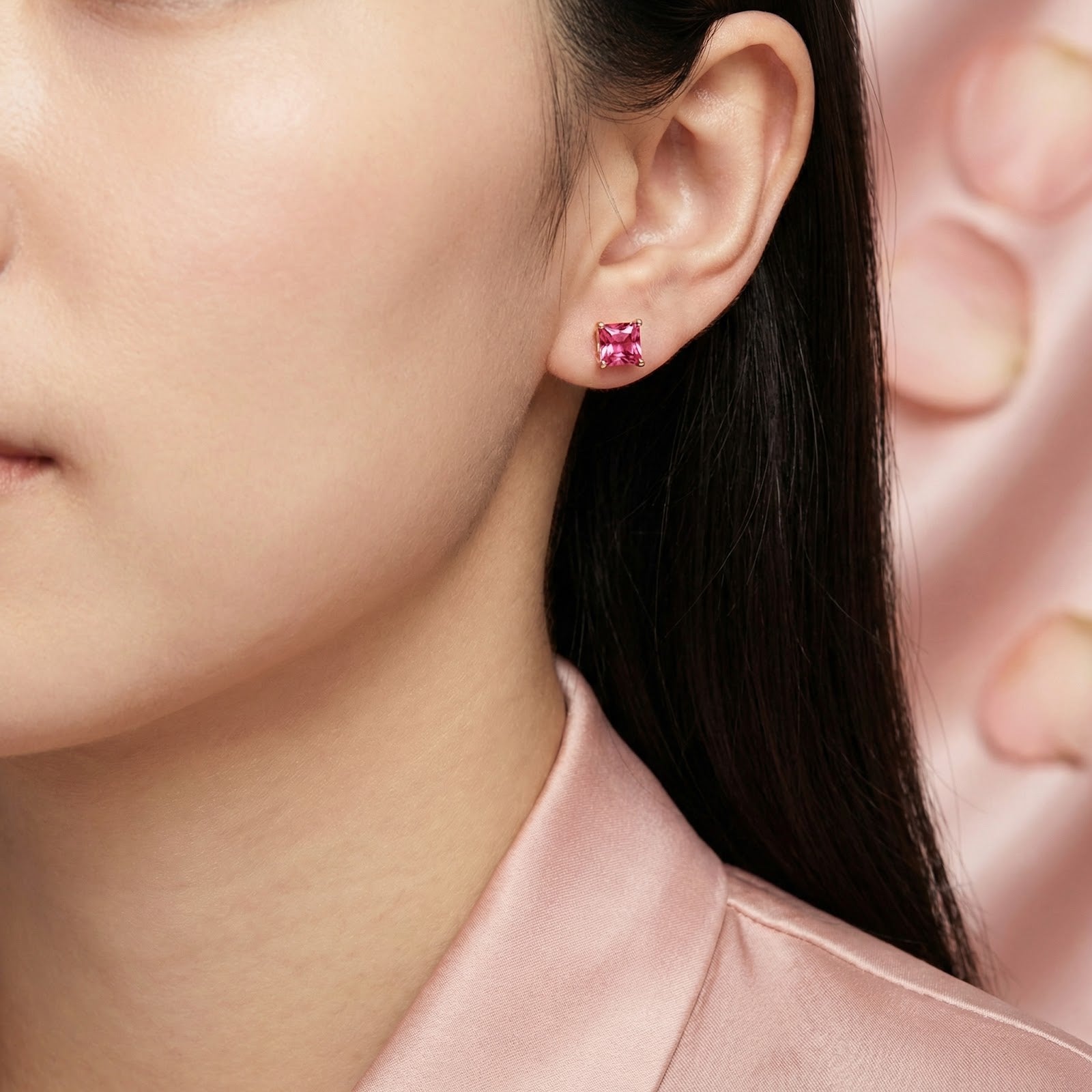 Woman with dark hair wearing a square simulated pink tourmaline stud earring in 18K rose gold vermeil.