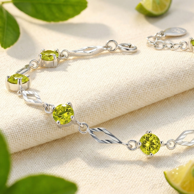 Close-up of round-cut simulated peridot stones in a prong-set S925 sterling silver station bracelet.