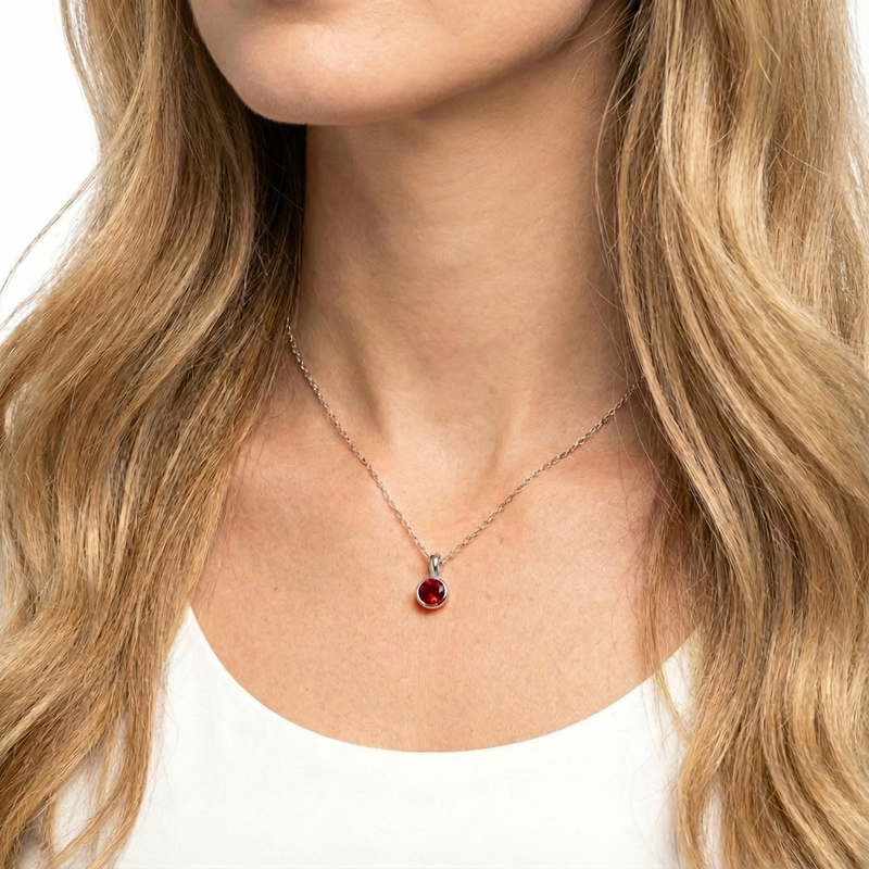 Close-up of a woman wearing the S925 sterling silver July birthstone necklace with a simulated ruby.