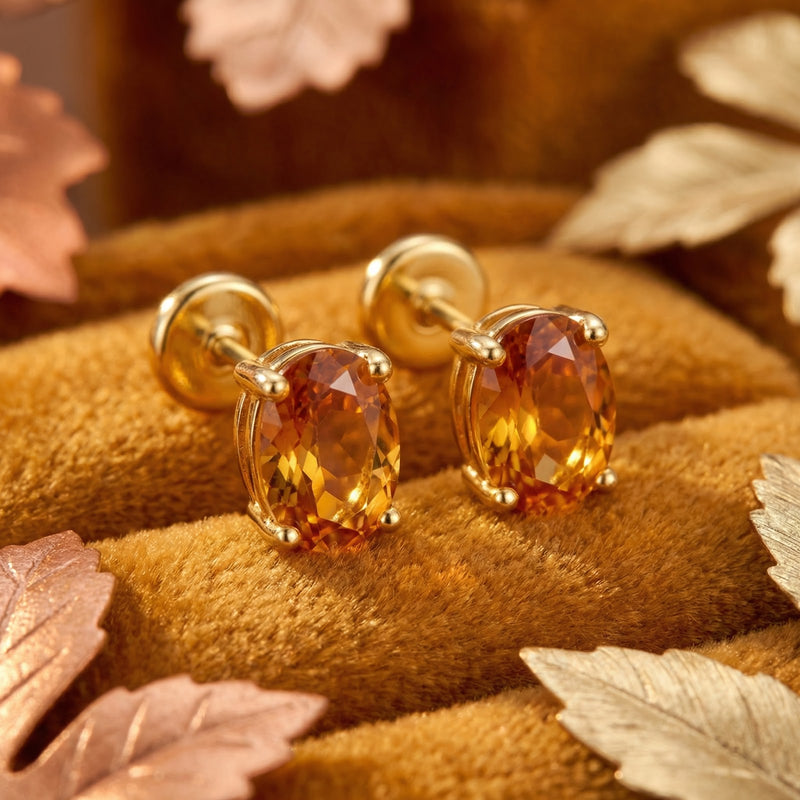 Macro view of oval cut honeyed simulated topaz stud earrings in 18K gold vermeil prong settings.
