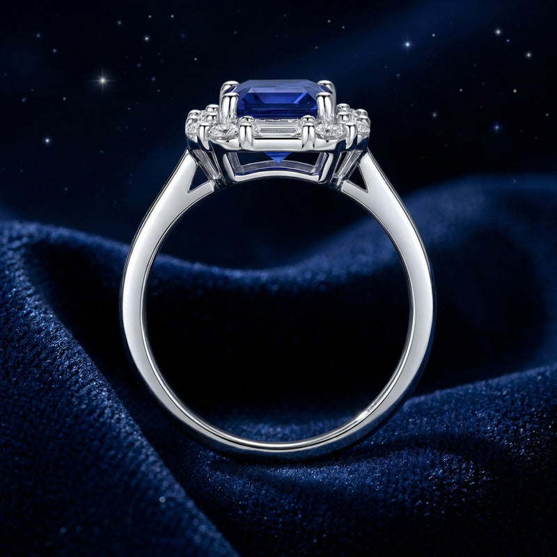Side profile of the S925 sterling silver ring showing the simulated sapphire setting and band on blue velvet.