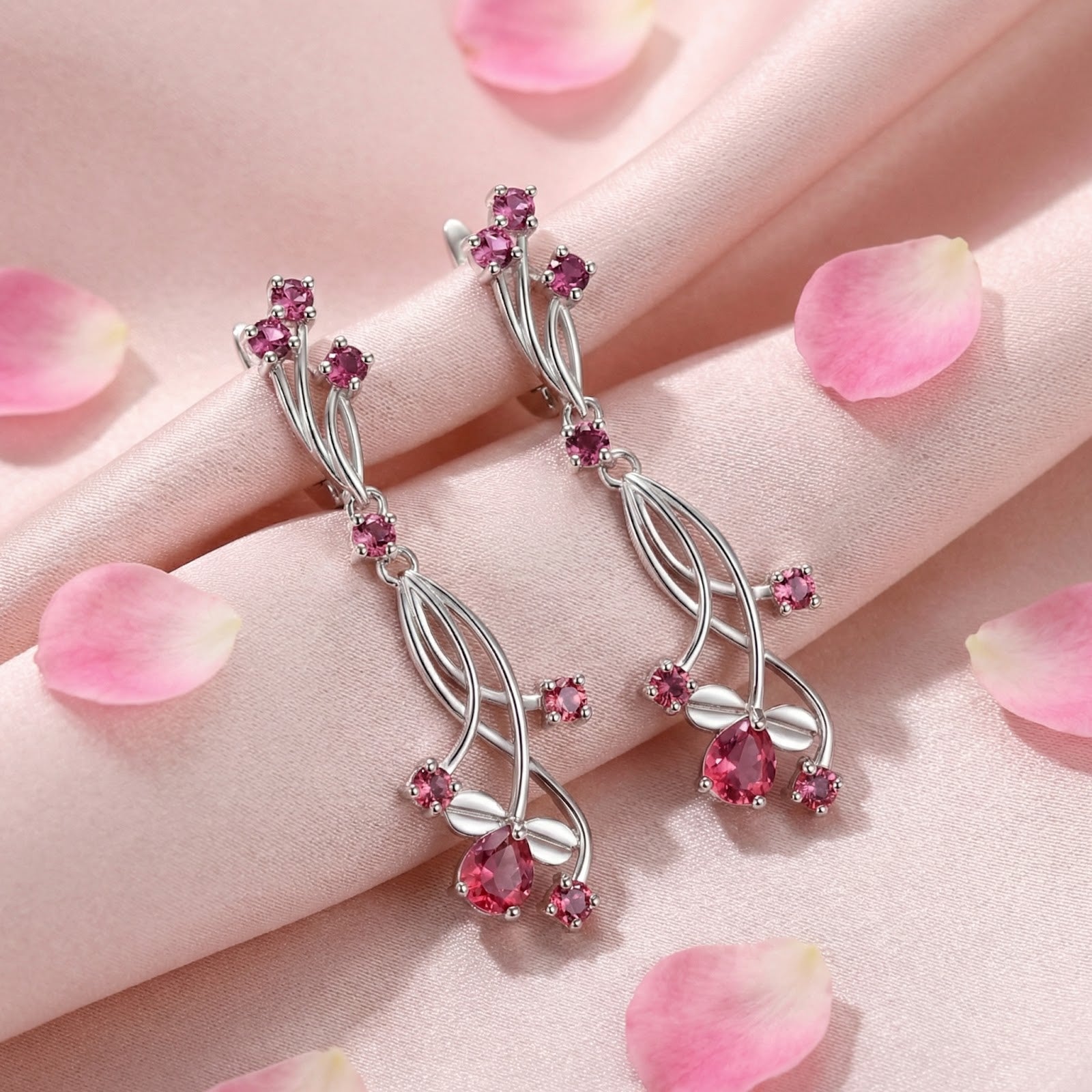 Sterling silver Rosaraea vine drop earrings with pear-cut pink tourmaline on pink silk with rose petals.