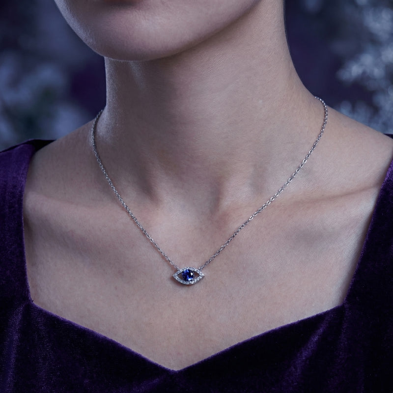 Model wearing the silver Ismeria Eye necklace with a round-cut simulated tanzanite center stone.