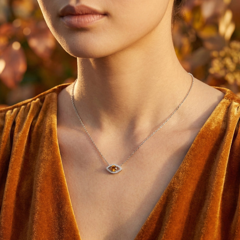 Woman wearing the sterling silver Hesperis Eye necklace with a round cut honey moissanite pendant.