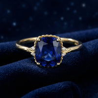 Front view of the Arisara cushion-cut simulated sapphire ring in 18K gold vermeil on blue velvet.