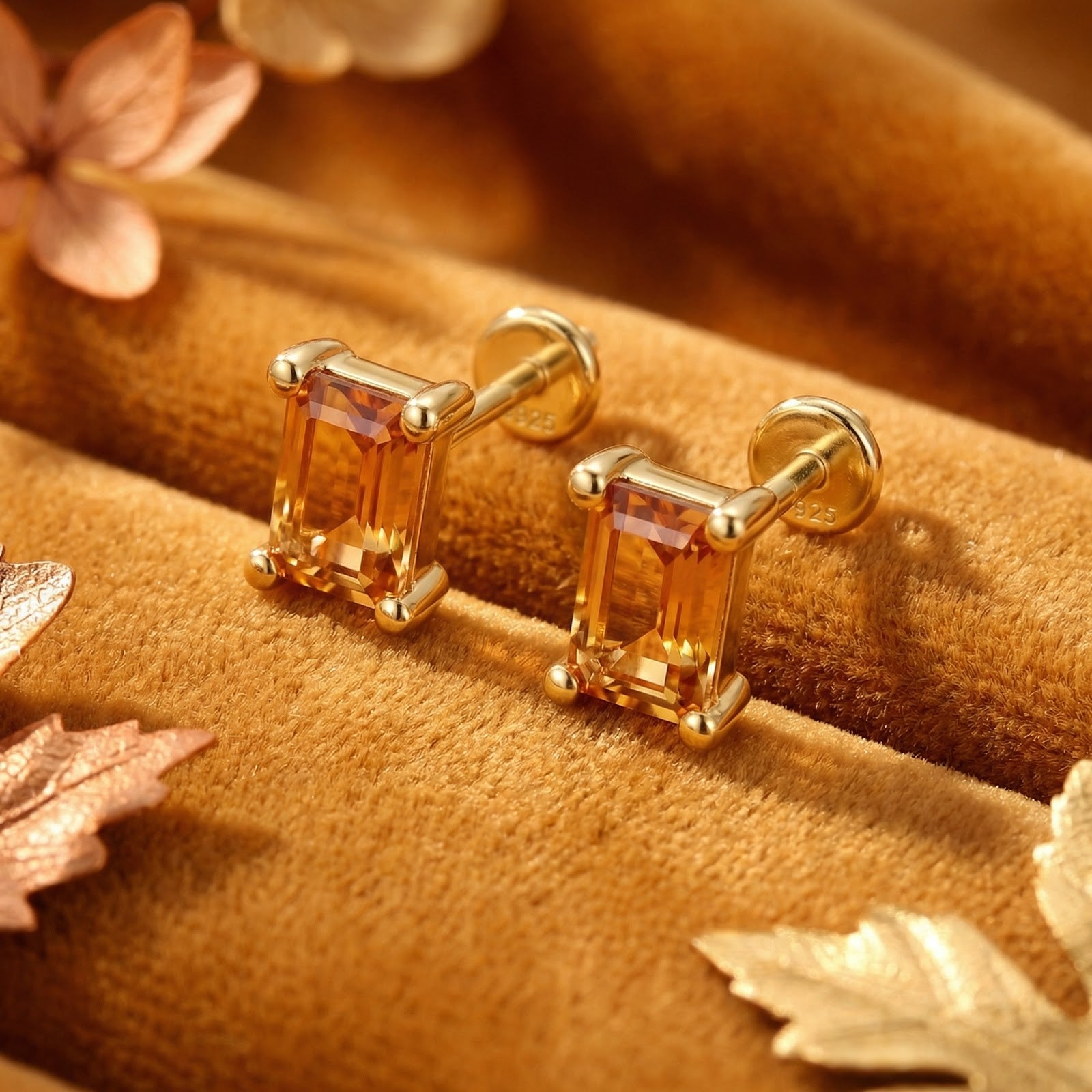 Close-up of 18K gold vermeil baguette stud earrings with simulated topaz stones and S925 hallmark on velvet.
