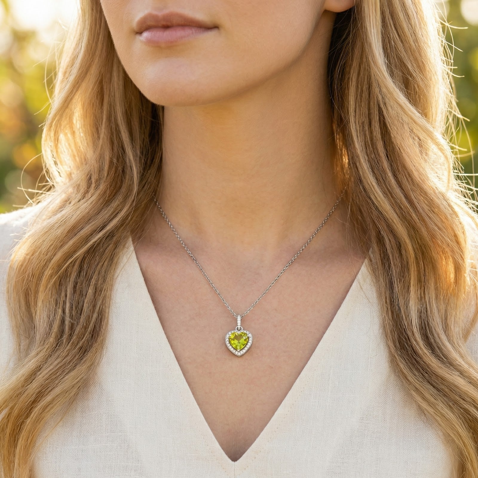 Woman wearing the Thalira Heart simulated peridot necklace in sterling silver, showing how it sits on the neckline.