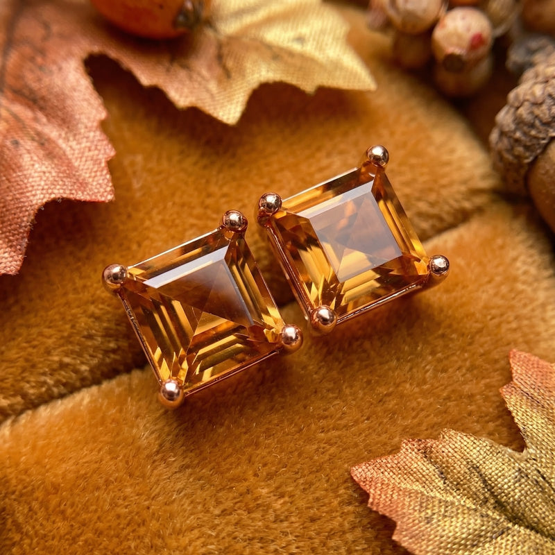 Macro view of square-cut simulated topaz stud earrings in 18K rose gold vermeil highlighting the stone's clarity.