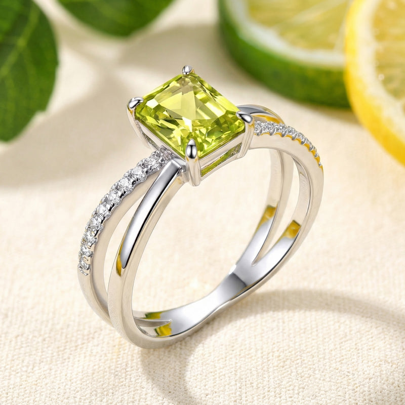 Angled view of the Aris radiant cut simulated peridot sterling silver ring with pavé criss-cross band.