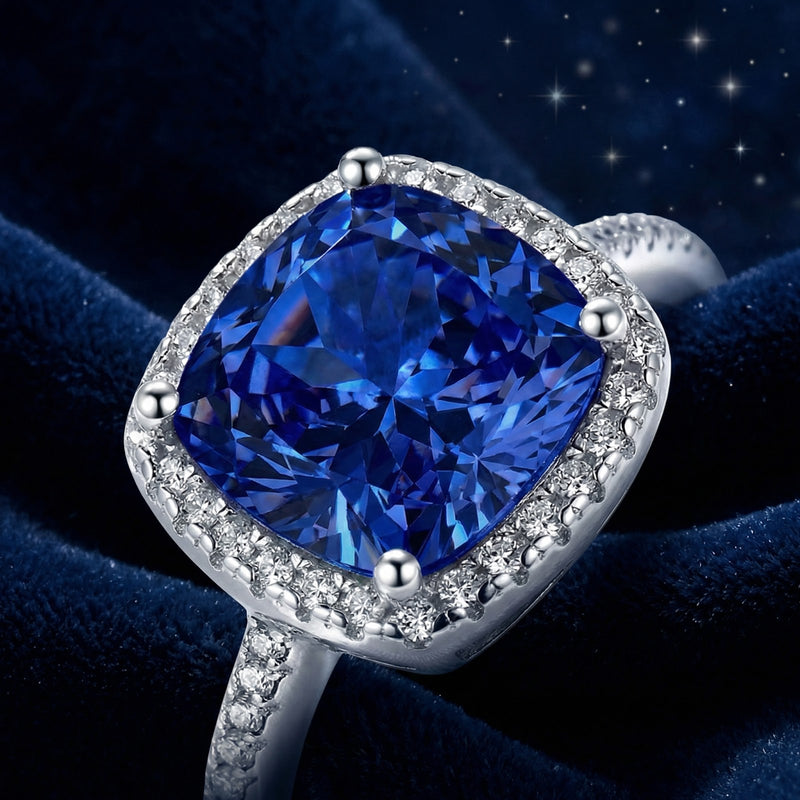 Macro view of a cushion-cut royal blue simulated sapphire and precision-set halo in sterling silver.