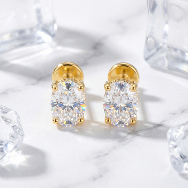 Front view of a pair of oval cut zirconia stud earrings in 18K gold vermeil on marble.
