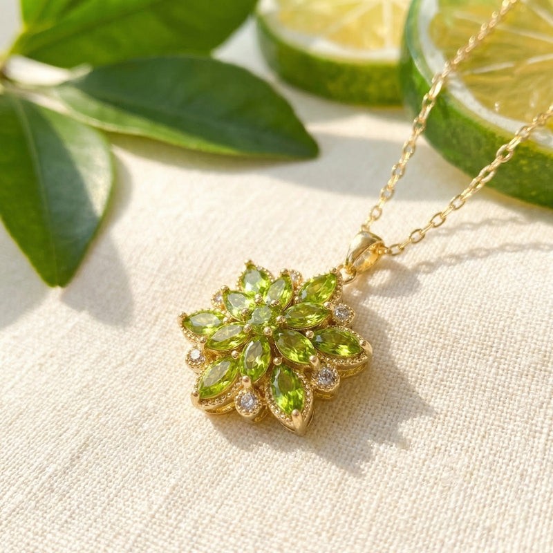 Close-up of a gold stainless steel floral pendant featuring marquise-cut simulated peridot and clear accent stones.