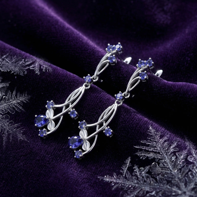 Thalinea sterling silver vine drop earrings with blue-violet simulated tanzanite on purple velvet with crystals.