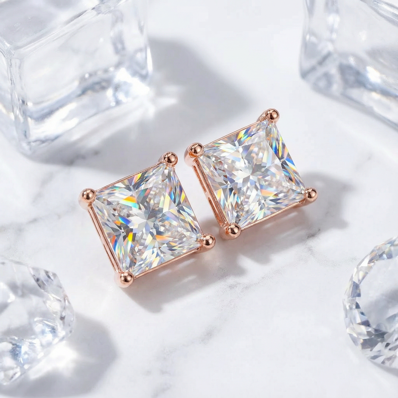 Close-up of princess cut zirconia stud earrings in 18K rose gold vermeil showing the four-prong setting and facets.