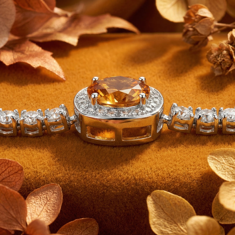 Macro view of a round-cut golden simulated topaz in a sterling silver halo setting with pavé accent stones.